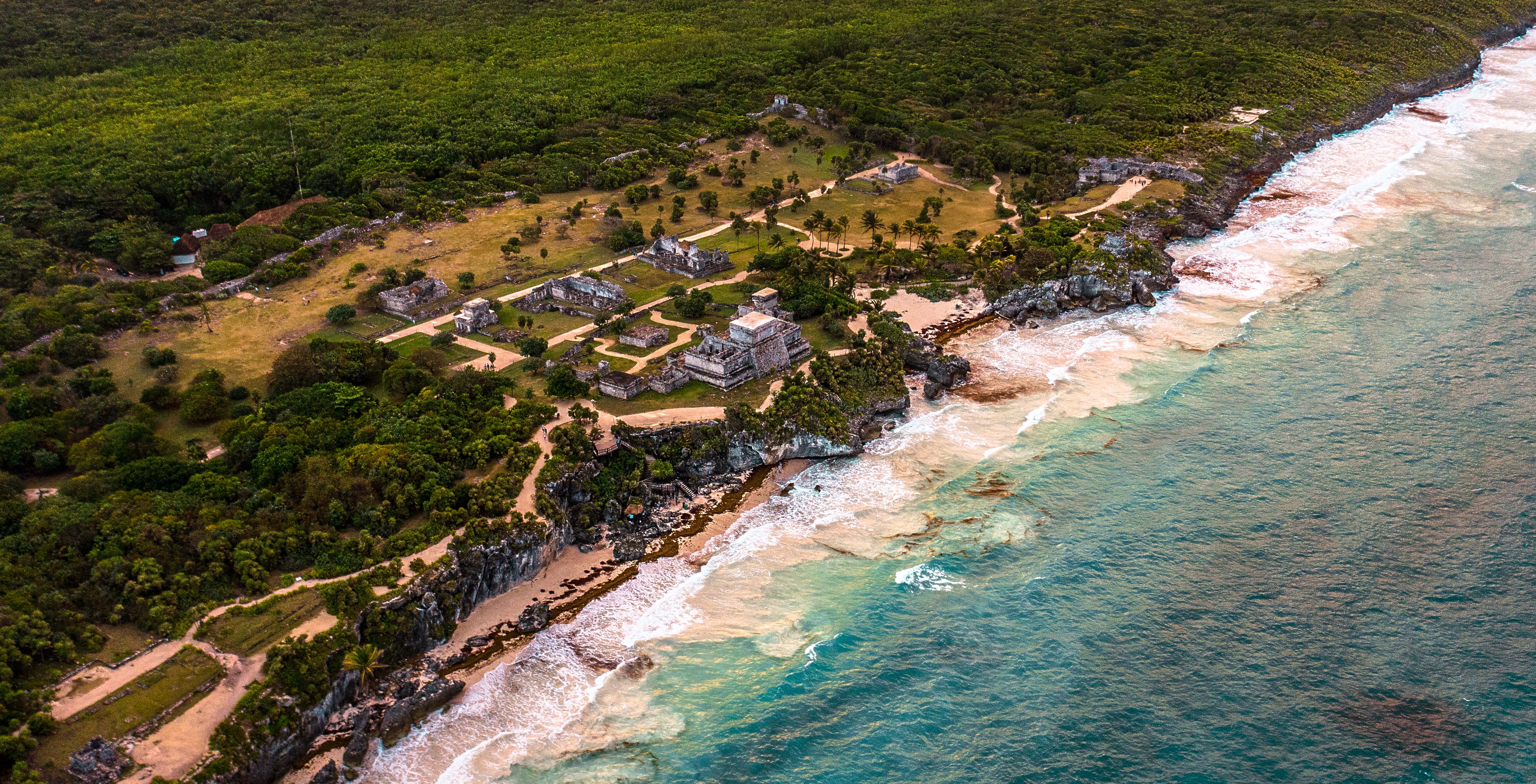 图卢姆全景航拍——内城贴着悬崖展开，城堡、礁口、海滩与城墙关系一目了然。