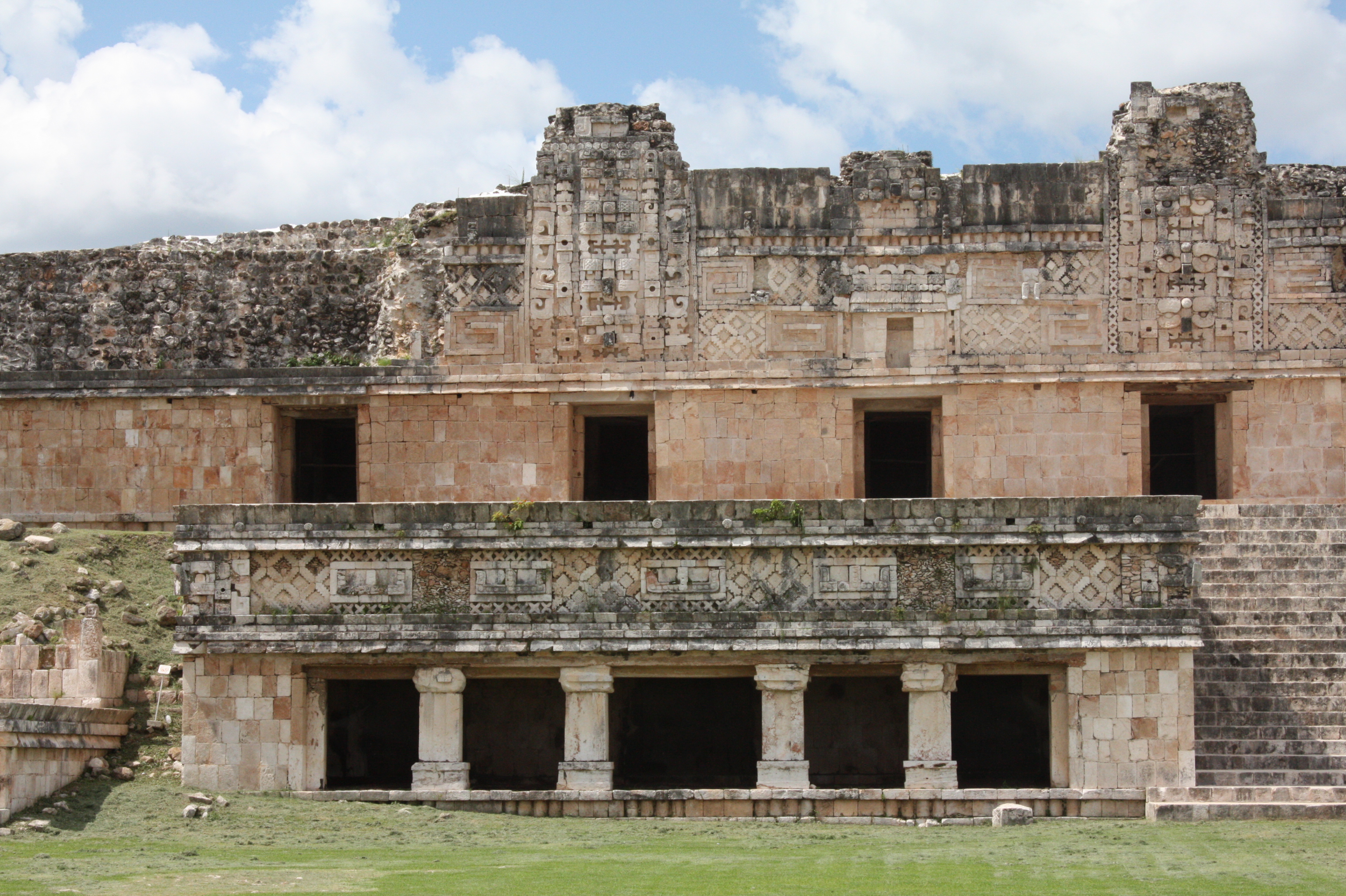 修女修道院外墙上的查克面具——卷鼻、圆眼与层层堆叠的构图，是雨神崇拜最醒目的视觉表达