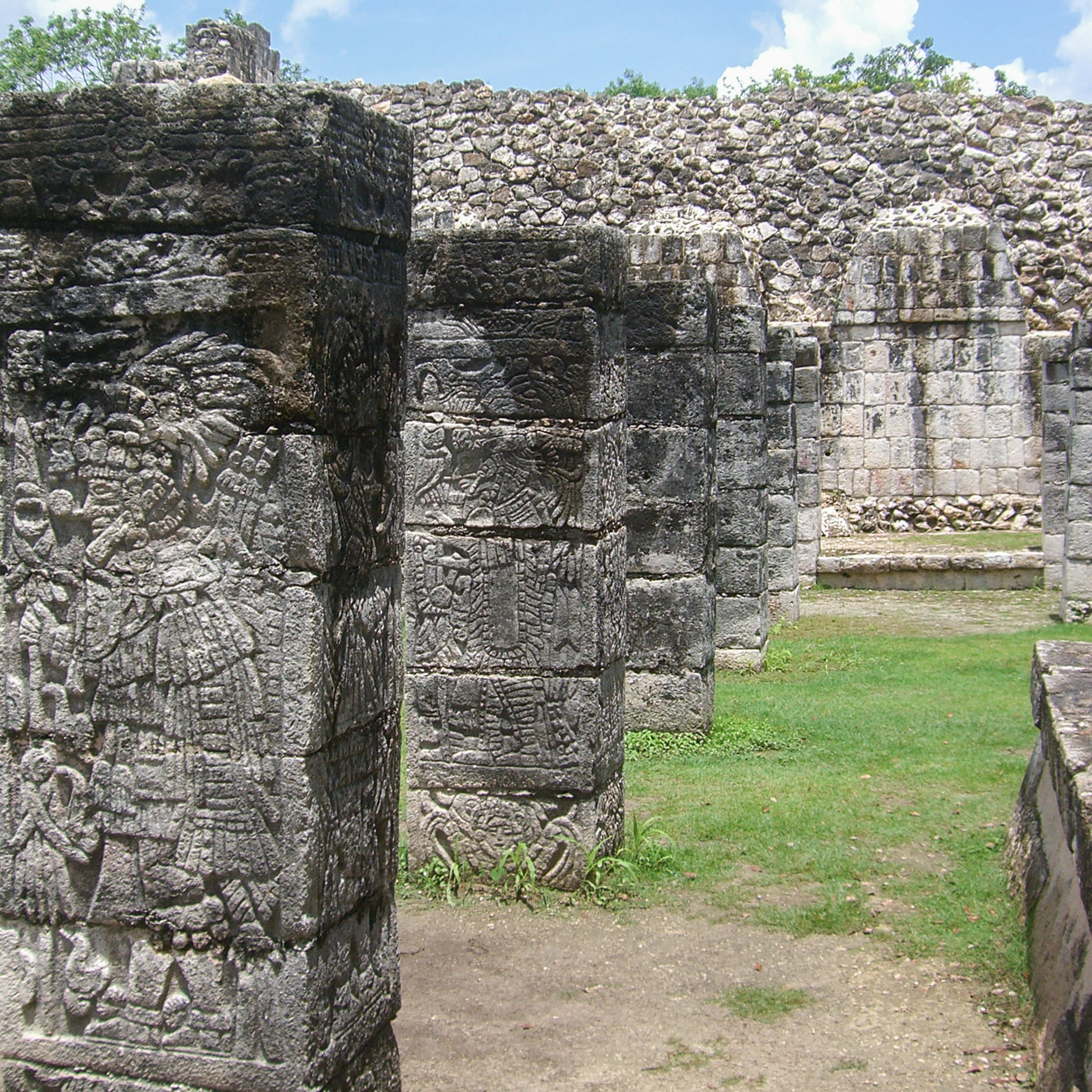 武士神庙正面——四层阶梯金字塔前矗立着数百根刻有战士浮雕的石柱，顶部的查克穆尔雕像俯视广场